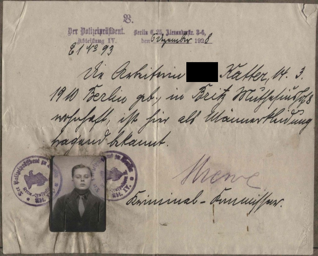 Approximately A5 sized piece of paper with text: The police president department IV. E1 No 93, Berlin E 25 Alexanderstr. 3.6, 6th of September 1928. The worker (deadname blackened) Katter, born 14.3.1910 in Berlin, resident in Britz Muthesiushof 8 is known here for wearing men's clothes.